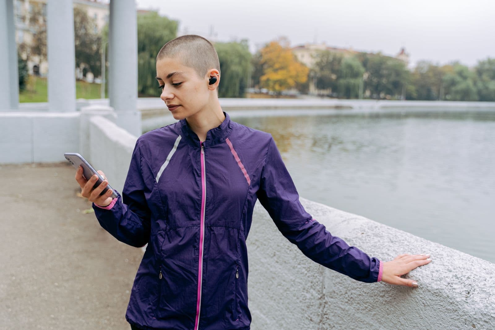 Woman in a purple running jacket looking at her mobile phone
